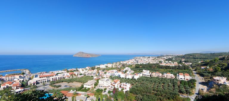 Kreeta, Platanias 2 Panoraamanäkymä ylhäältä rannalle, jossa paljon vaaleita rakennuksia.