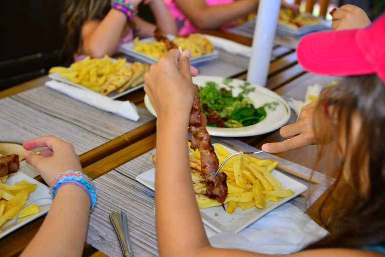 Kreikka, yleinen, perhe 7 Lapsia syömässä souvlakia kreikkalaisessa ravintolassa.