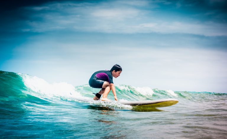 Kreikka, Rodos, surffaus Nuori poika surffilaudalla pienessä aallossa.