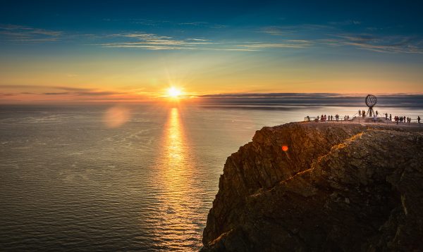 Ihmisiä ihailemassa keskiyön aurinkoa Nordkapissa.